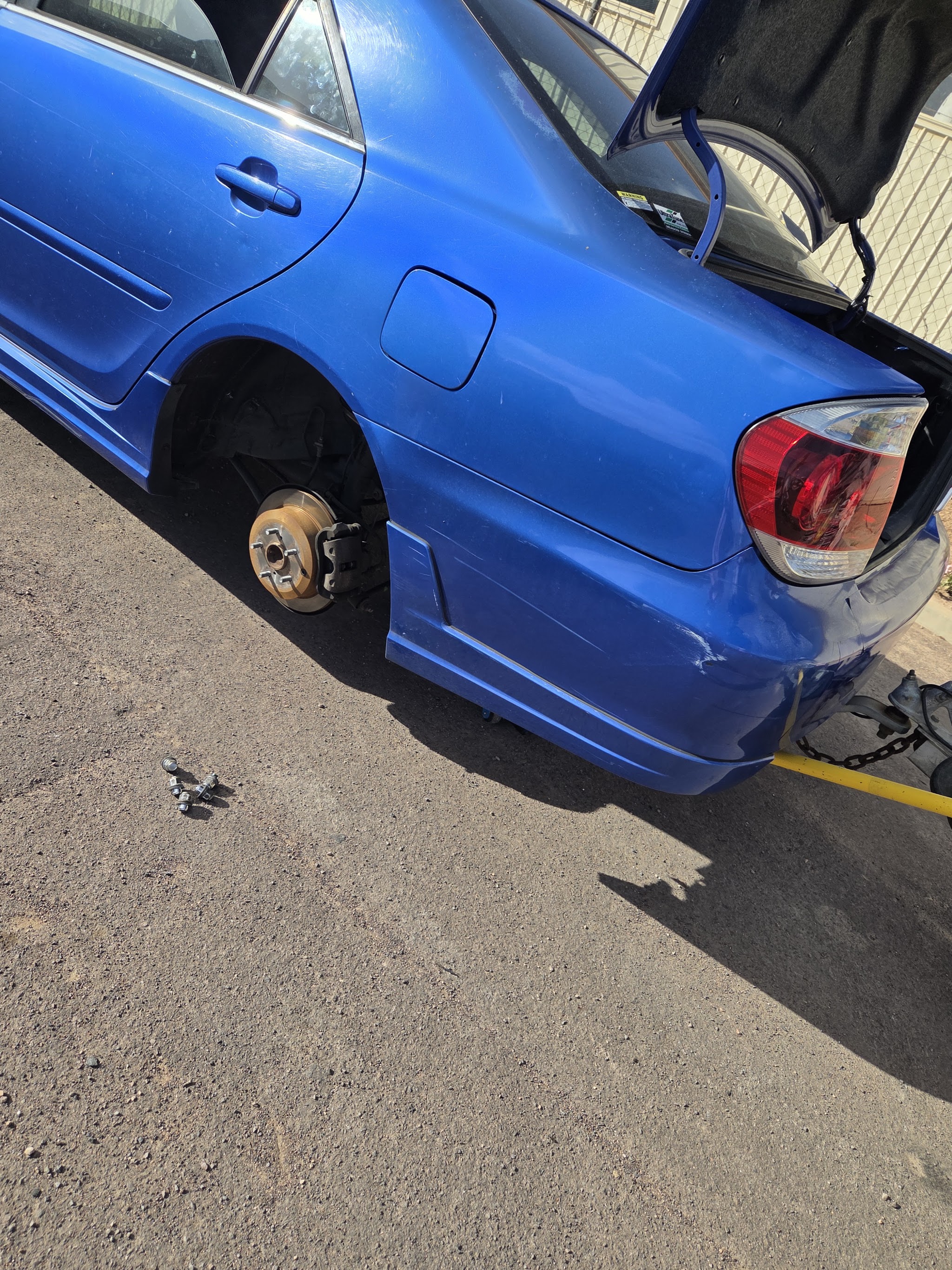 A car on the forecourt with the rear wheel removed