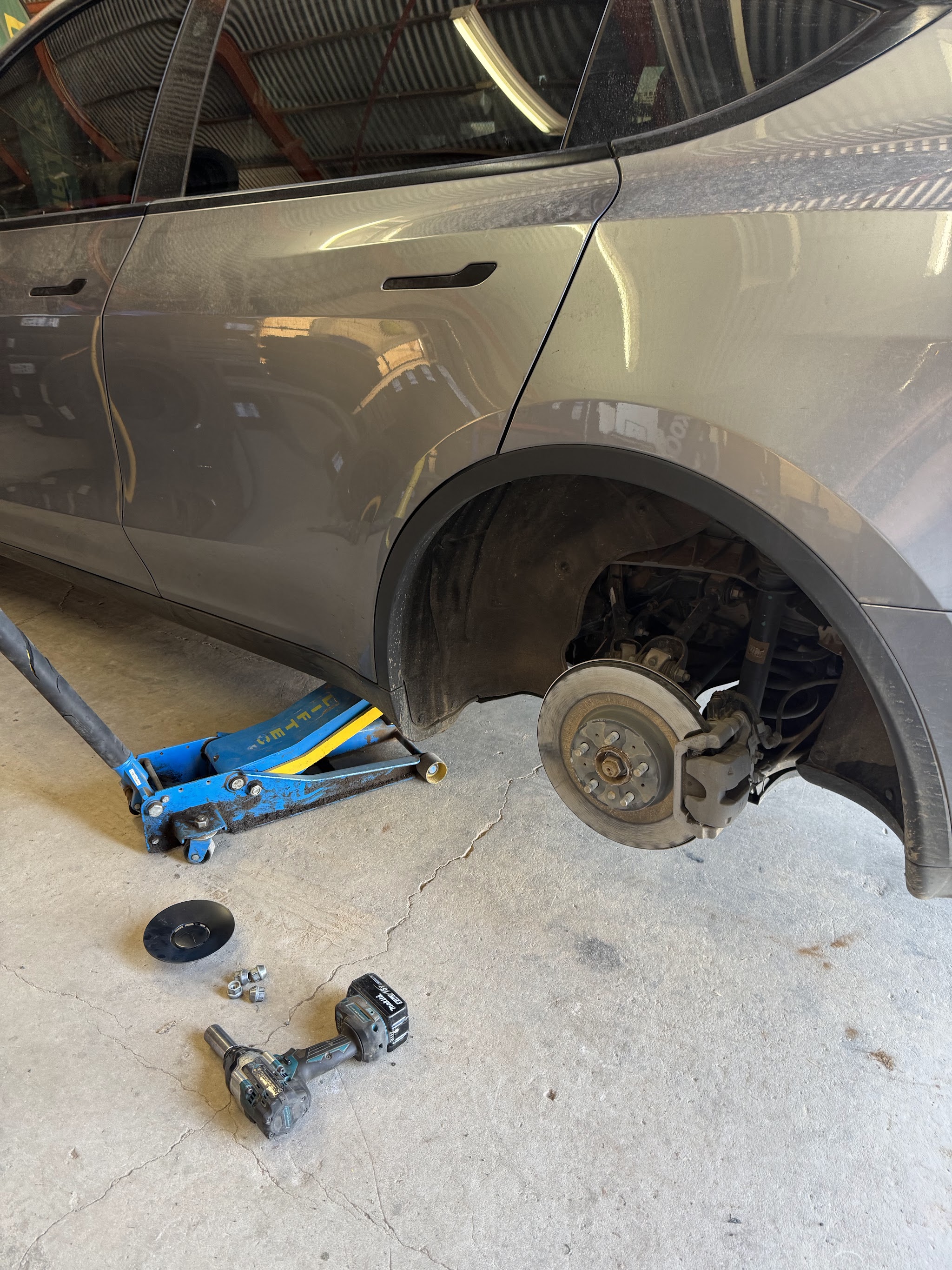 A car up on the jack with a wheel off